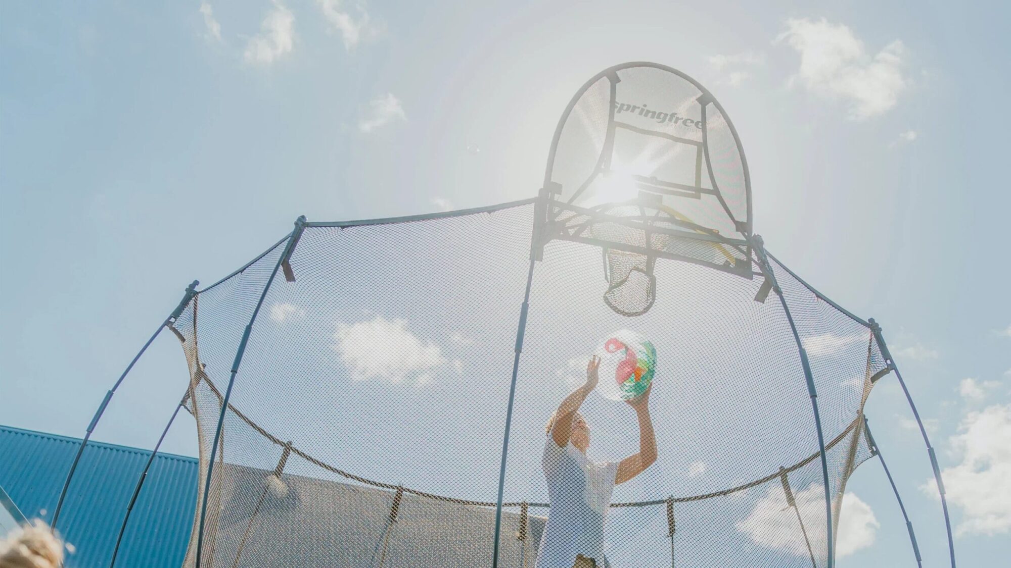 Dítě skáče na trampolíně Springfree za slunečného dne