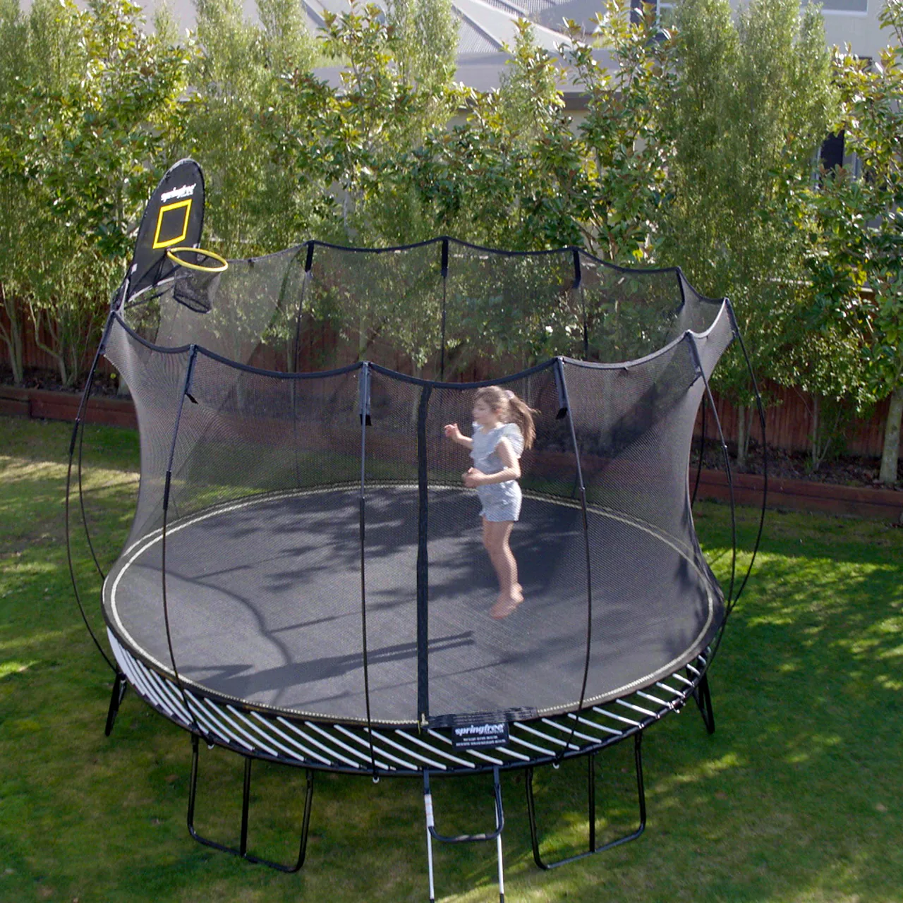 Trampolína Springfree Jumbo Round R132 na zahradě s dítětem