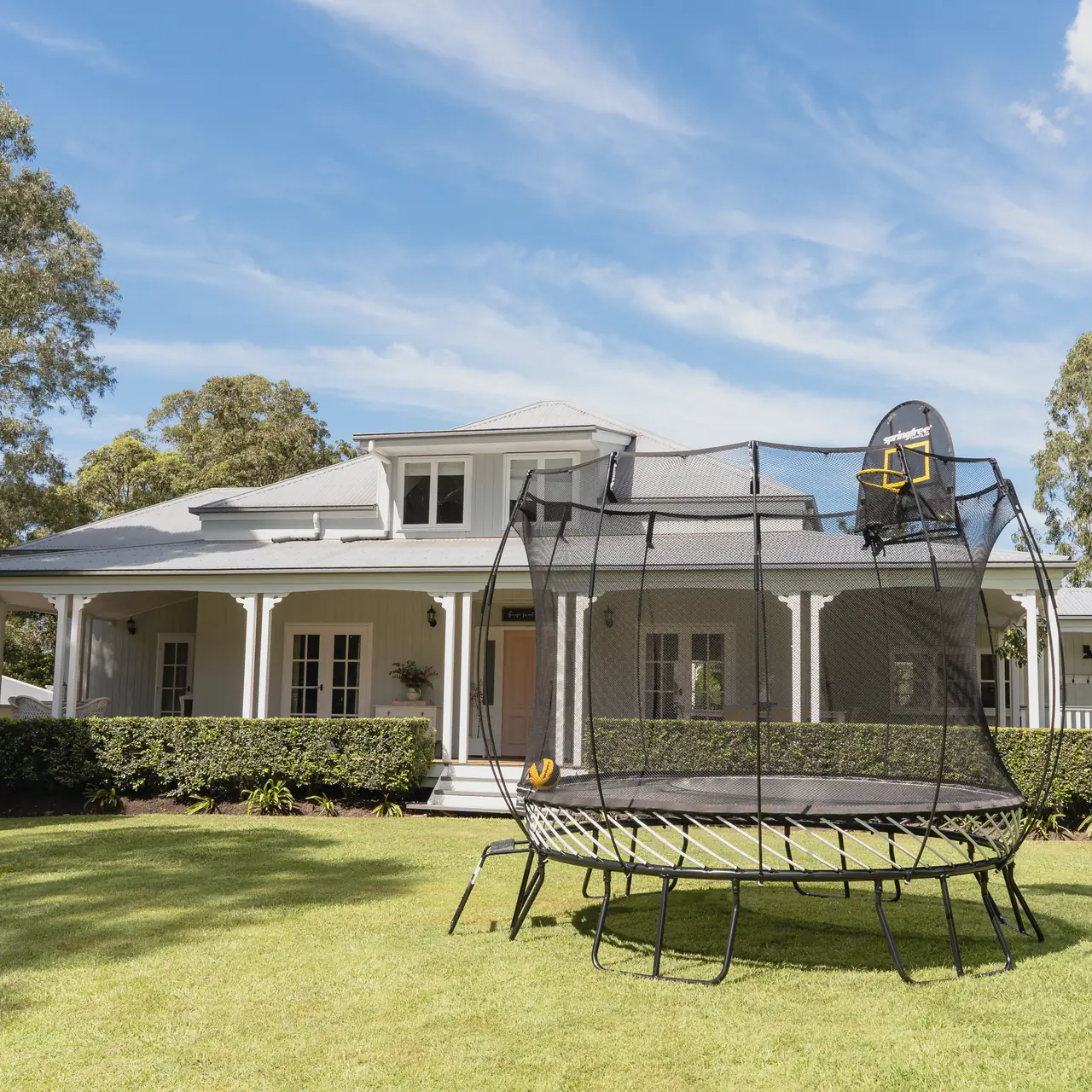 Trampolína Springfree s basketbalovým košem FlexrHoop na zahradě