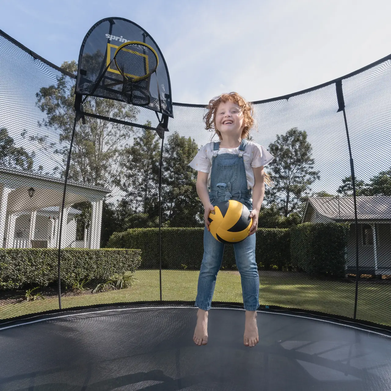 Dítě na trampolíně Springfree s basketbalovým košem FlexrHoop
