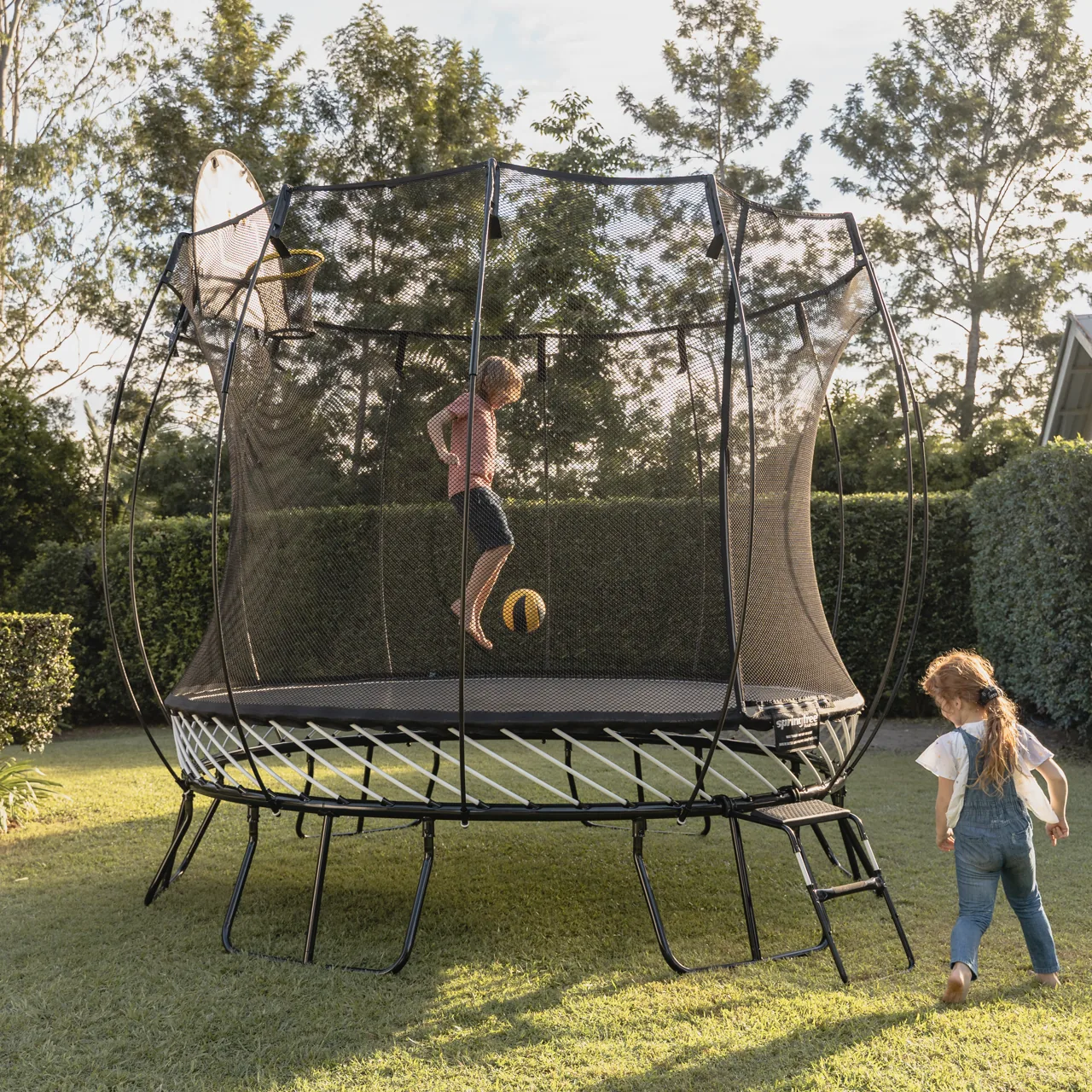 Děti u trampolíny Springfree Medium Round R79 na zahradě