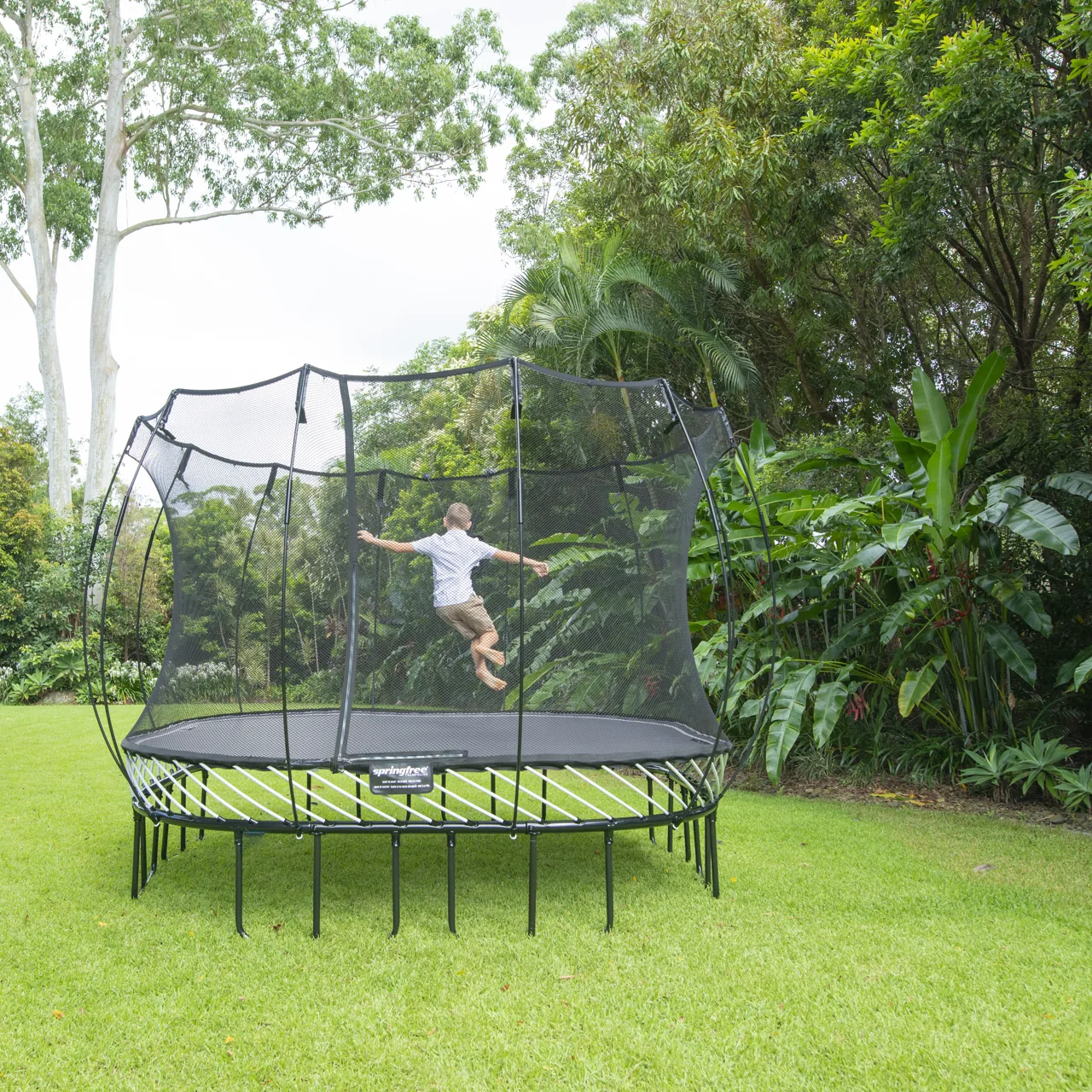 Dítě ve výskoku na trampolíně Springfree Large Square S113 v zahradě