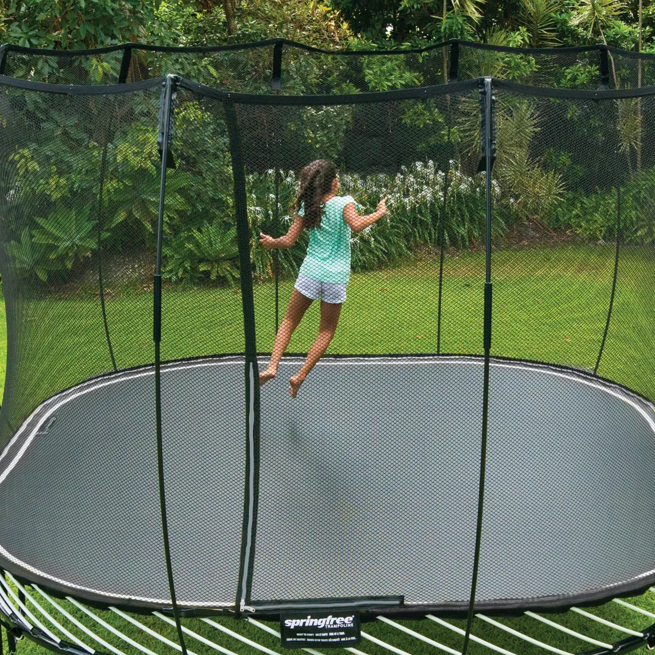 Dívka na trampolíně Springfree Large Square S113 na zahradě