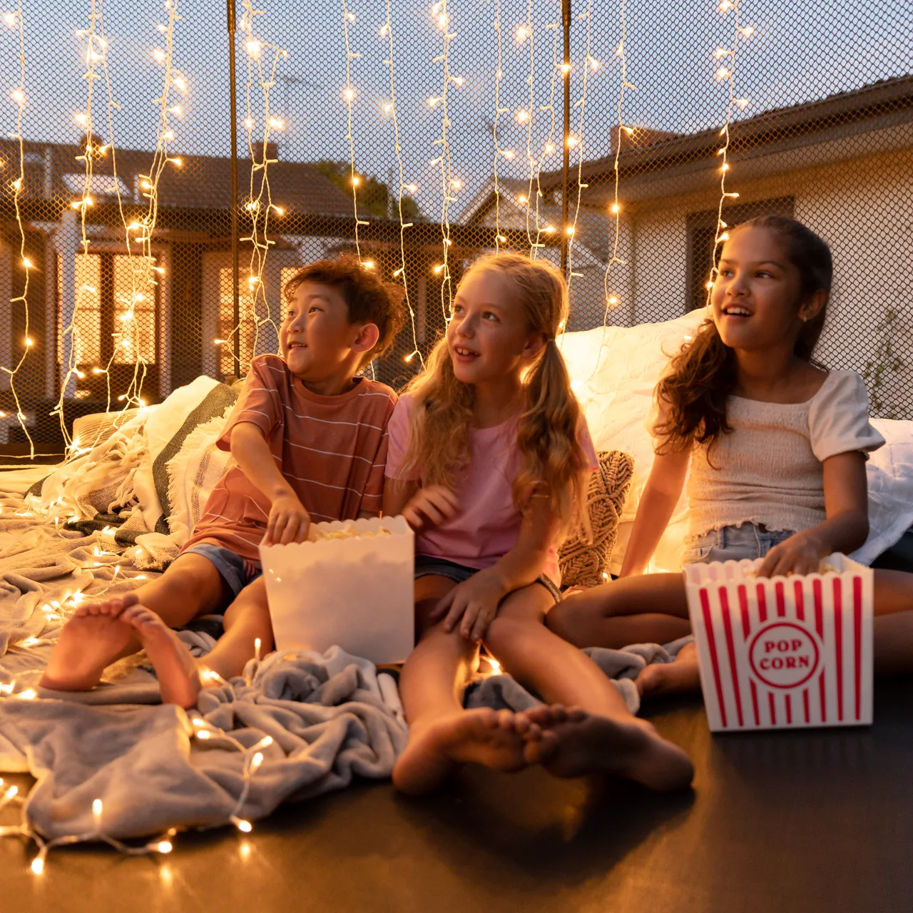 Děti na trampolíně Springfree Jumbo Round R132 při večerním promítání