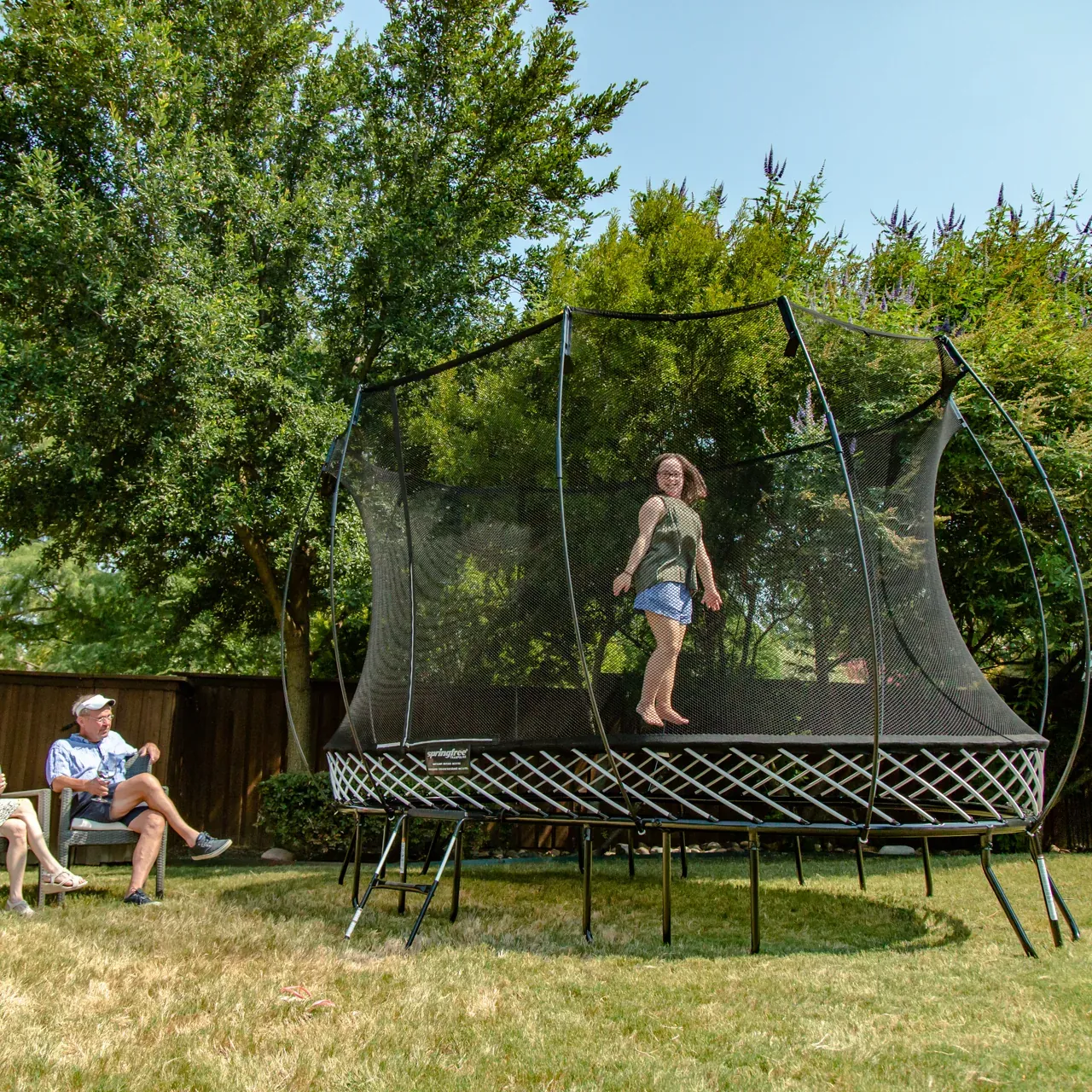 Dítě na trampolíně Springfree Medium Oval O77 na zahradě
