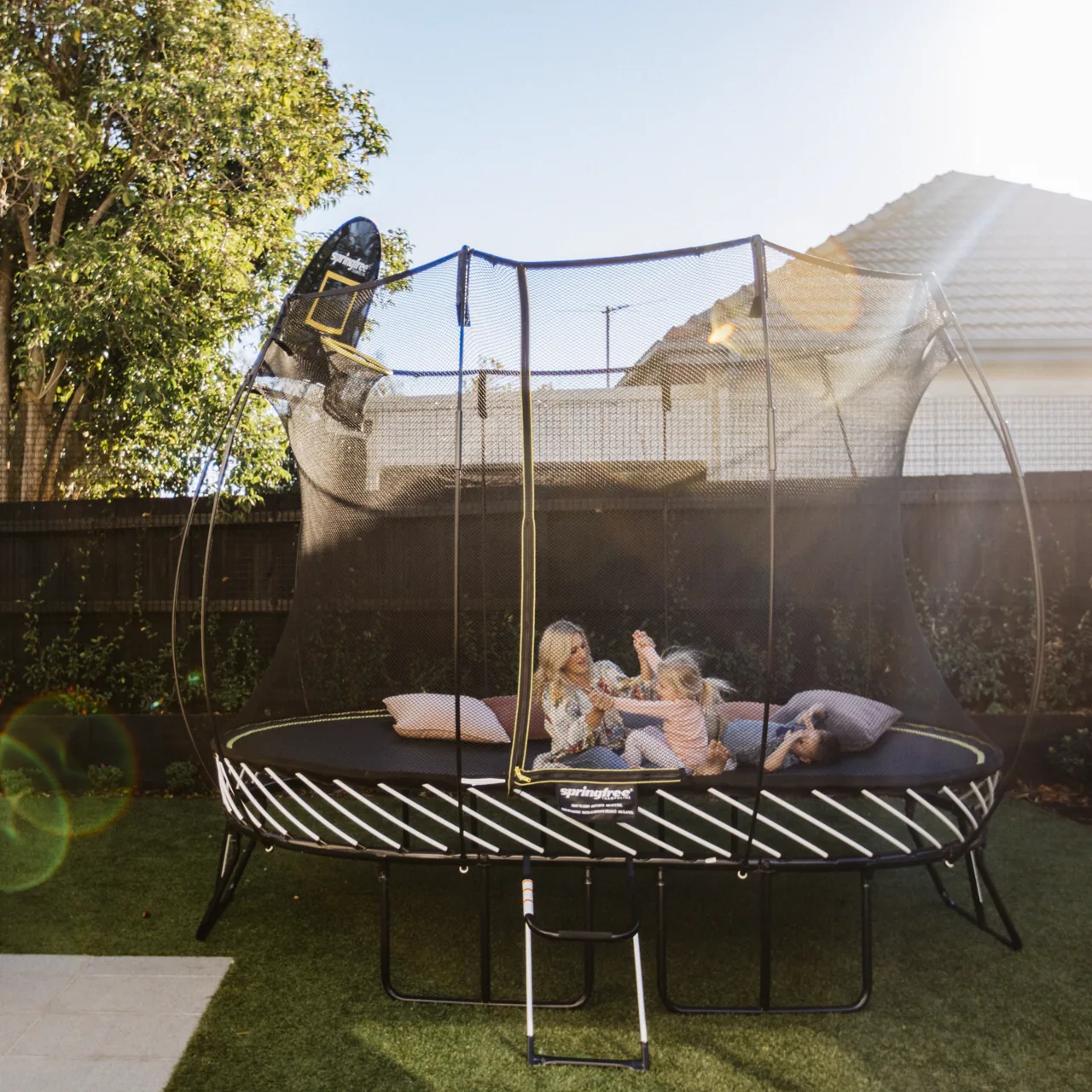 Trampolína Springfree Medium Oval O77 připravená k odpočinku na zahradě