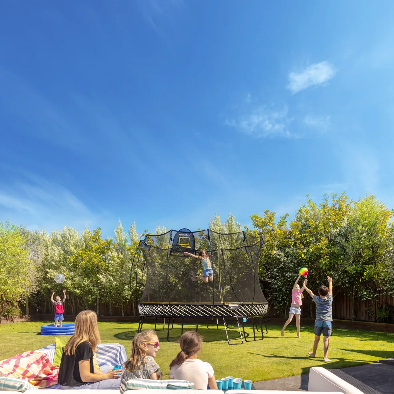 Trampolína Springfree Jumbo Round R132 na zahradě za slunečného dne